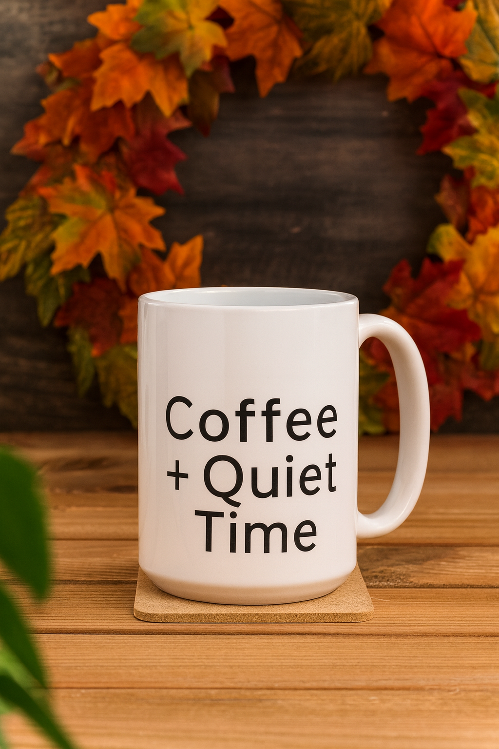 Coffee + Quiet Time mug on a wooden table with an autumn leaf wreath in the background.