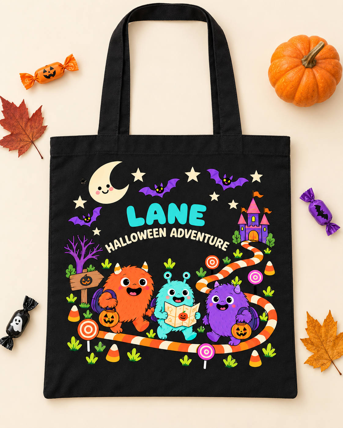Personalized black canvas Halloween trick-or-treat tote bag with the name LANE displayed with fall decorations