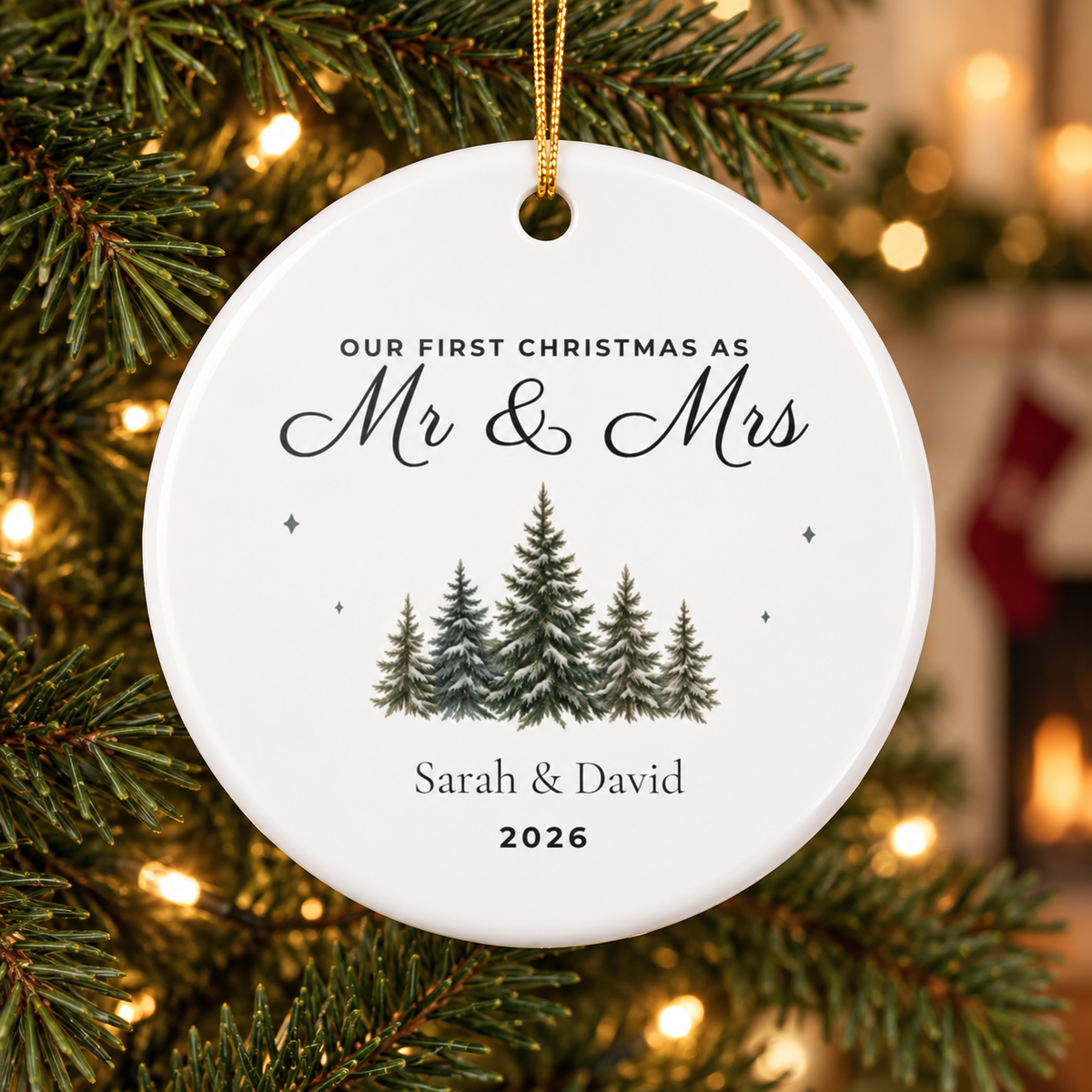 Personalized First Christmas Mr & Mrs ceramic ornament hanging on a Christmas tree with warm lights, evergreen artwork, sample names Sarah & David and year 2026.