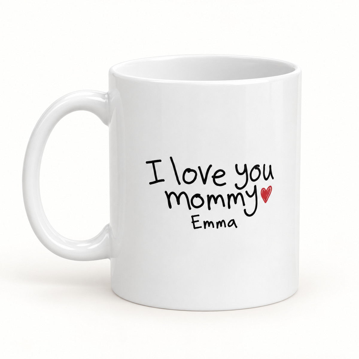 White 11 oz ceramic mug with sample child handwriting “I love you mommy,” Emma’s name, and a red heart.